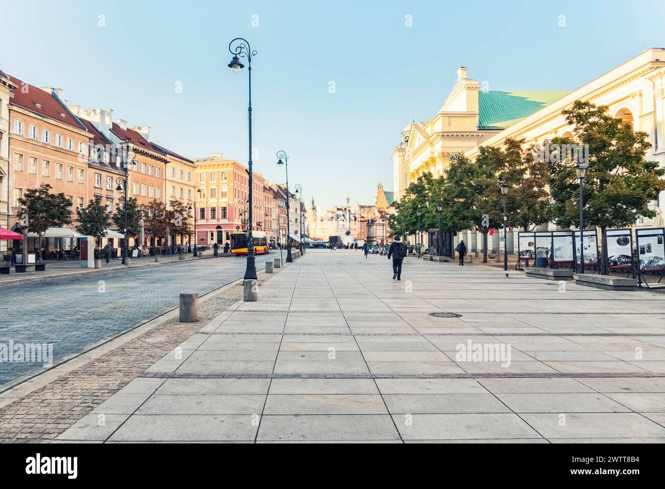 A peaceful morning on a European city street, with few pedestrians and historic buildings lining the way. Stock Photo