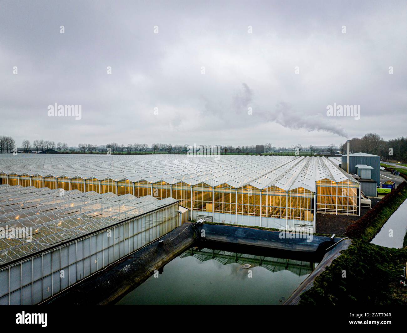 Expansive greenhouse complex under cloudy skies Stock Photo