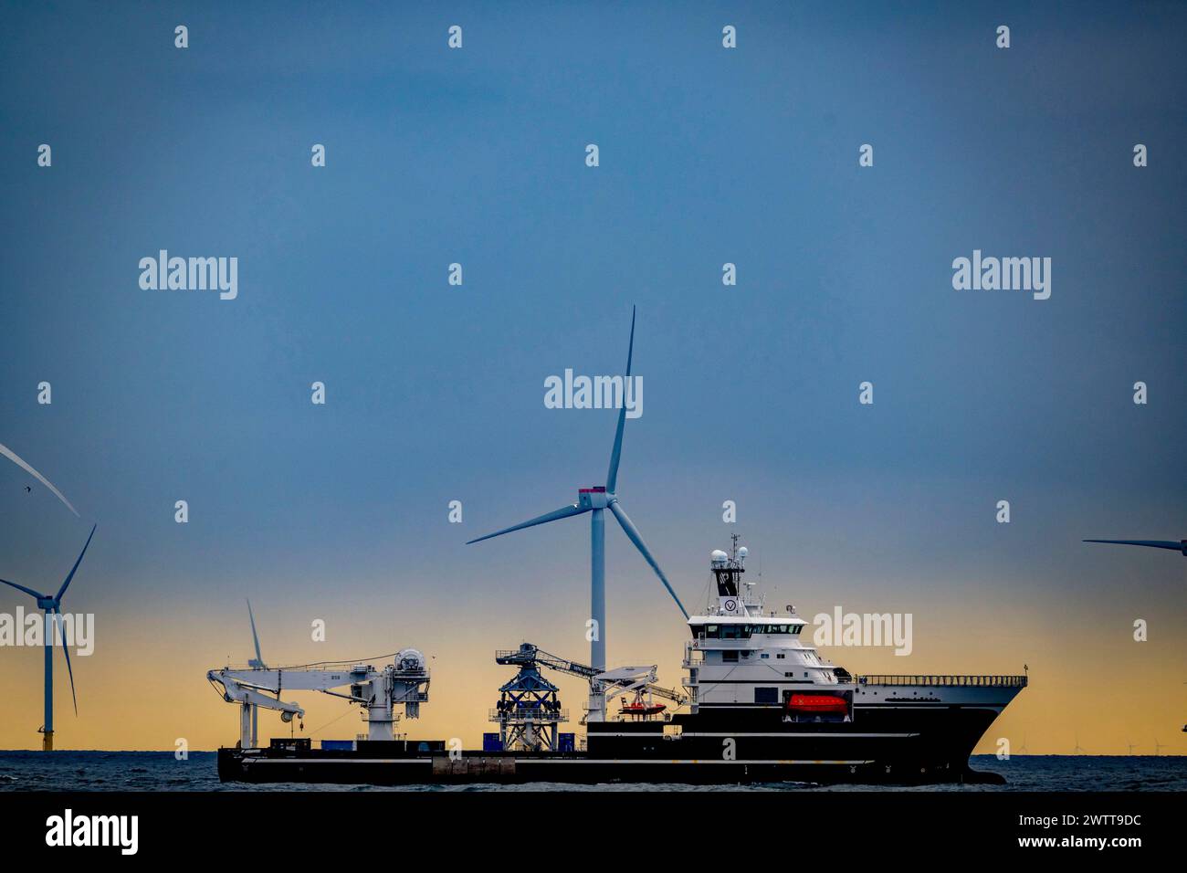 Offshore wind farm of vattenfall Hollandse Kust Zuid wind farm. transport ship in the distance Stock Photo