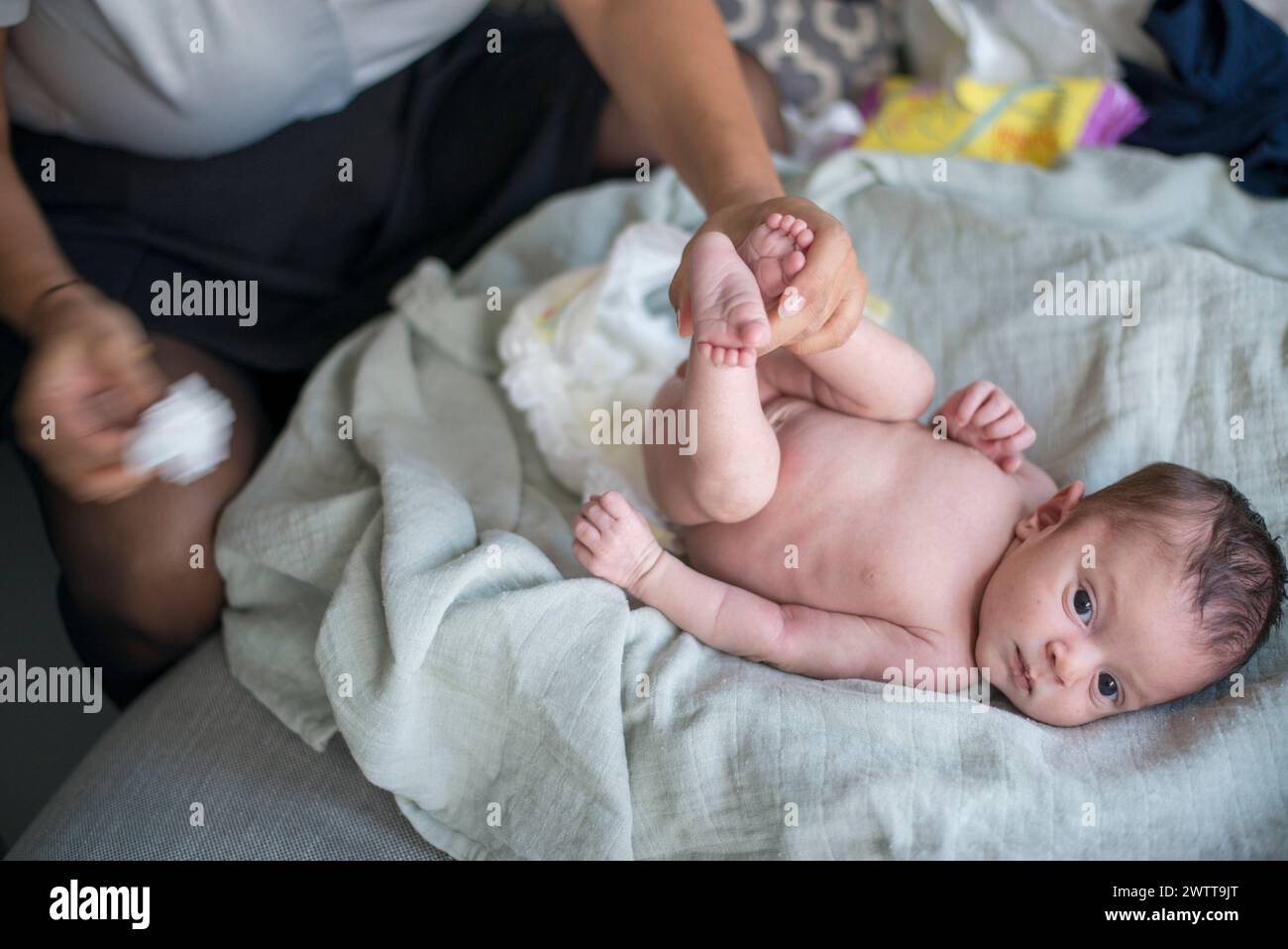 Tender moment during baby's diaper change Stock Photo