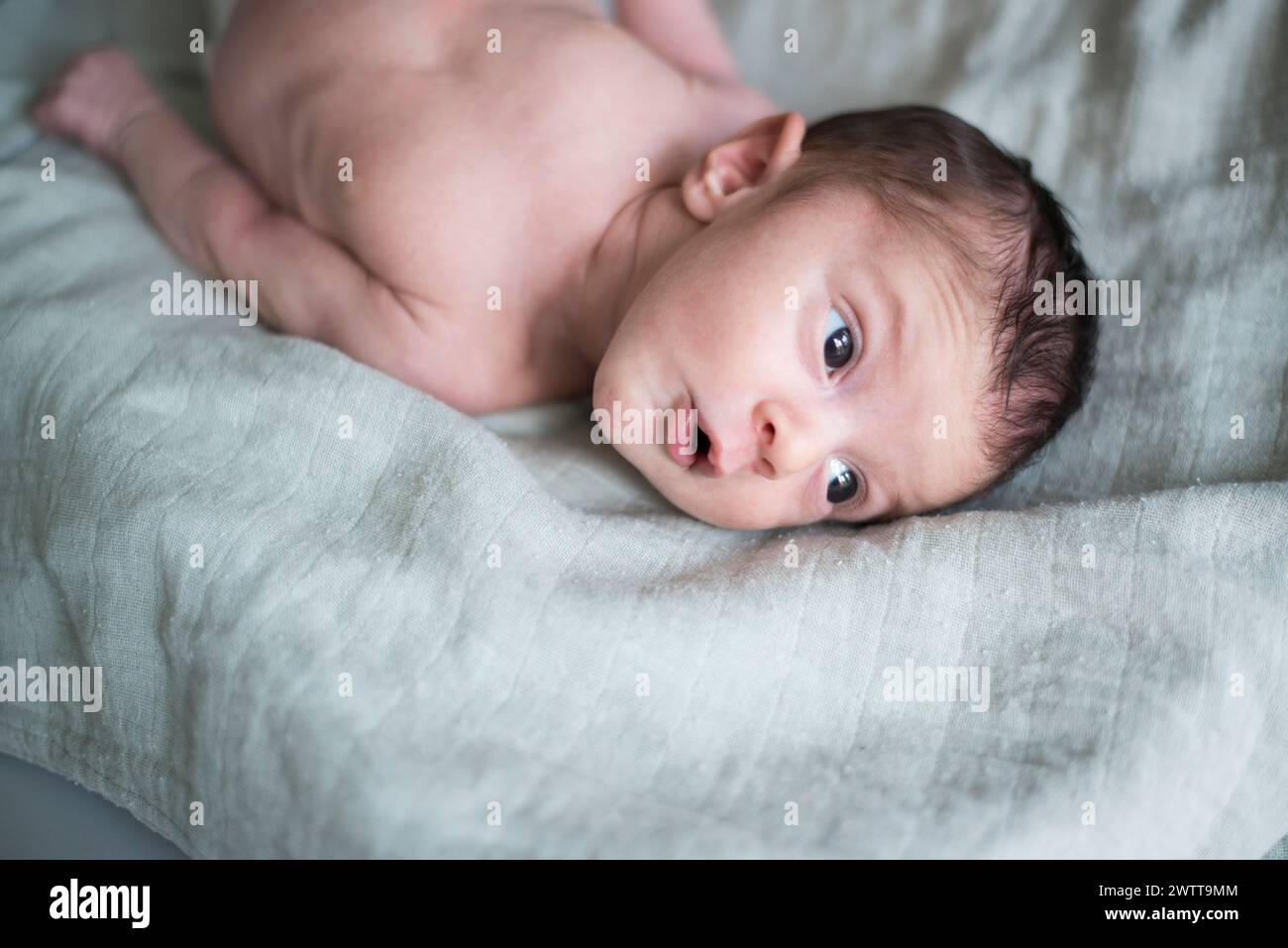 Innocent gaze of a newborn lying on soft linen Stock Photo