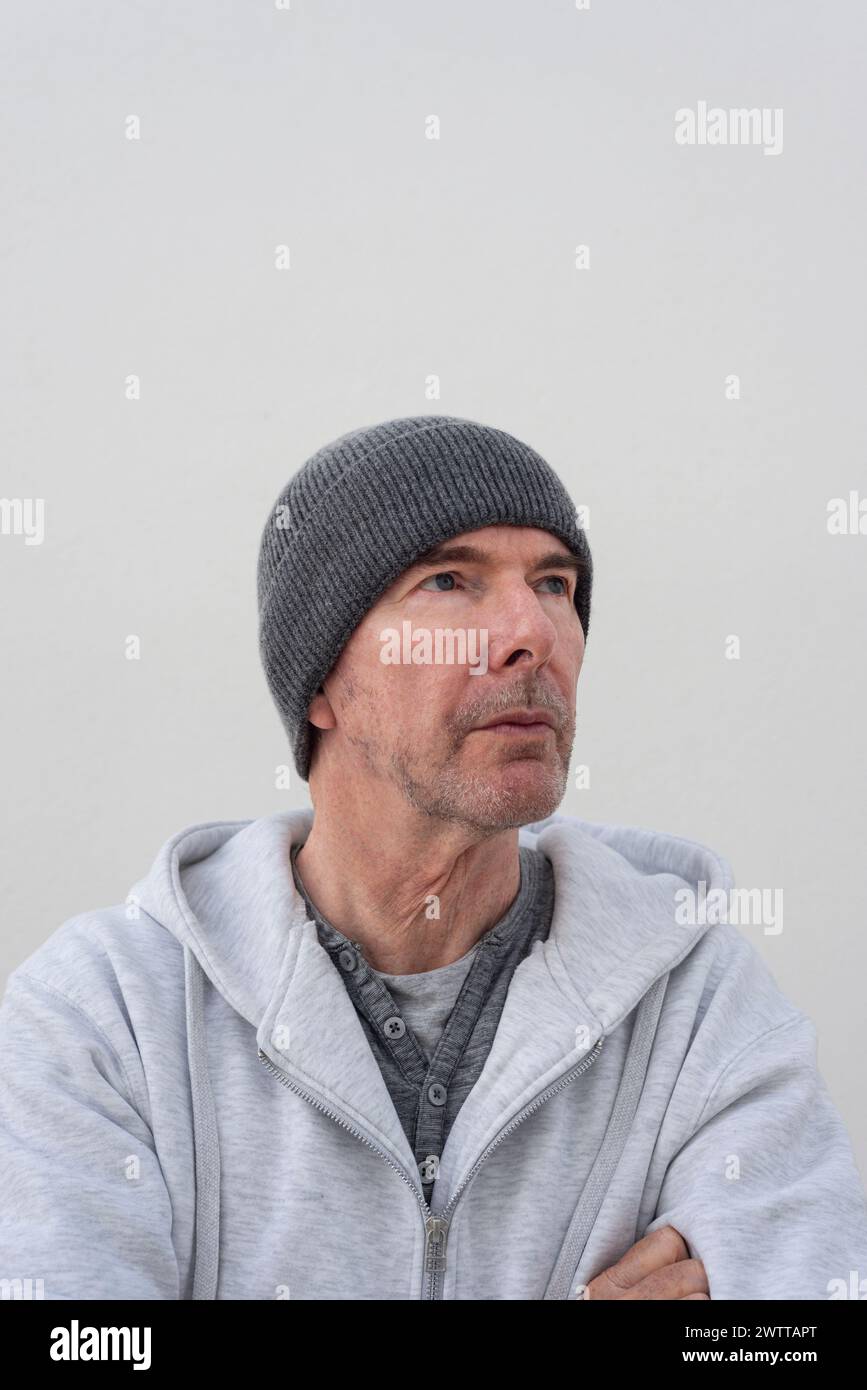 Portrait of a handsome mature man wearing a knit hat, looking away Stock Photo