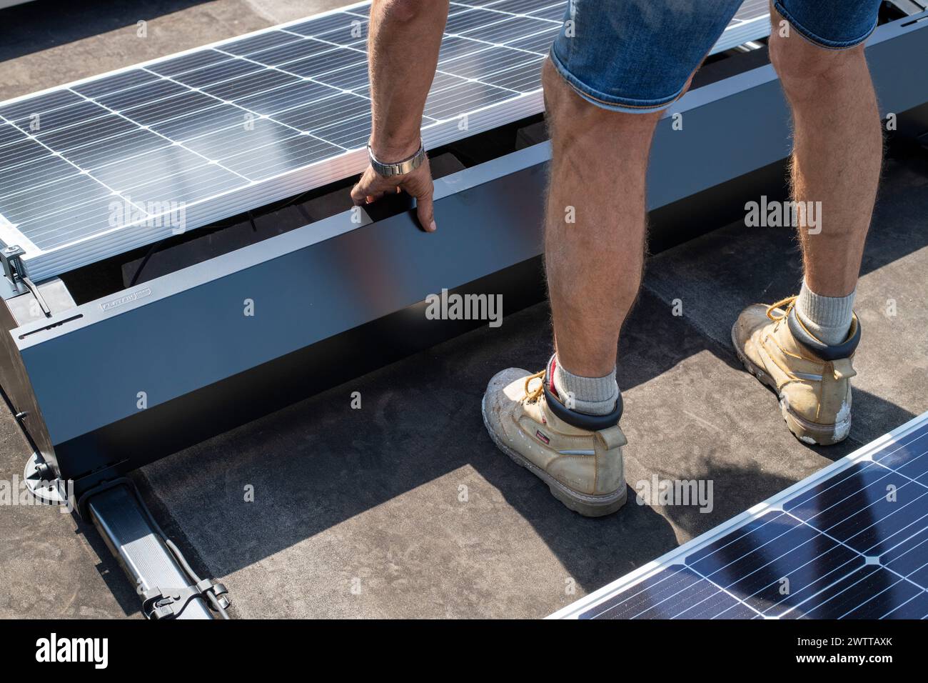 Worker installing solar panels on a sunny day Stock Photo