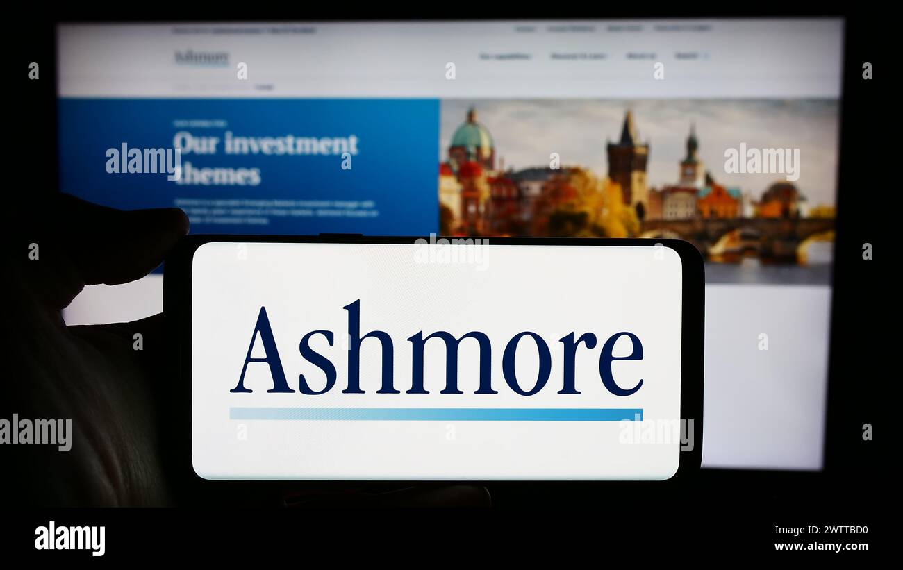 Person holding cellphone with logo of British investment management