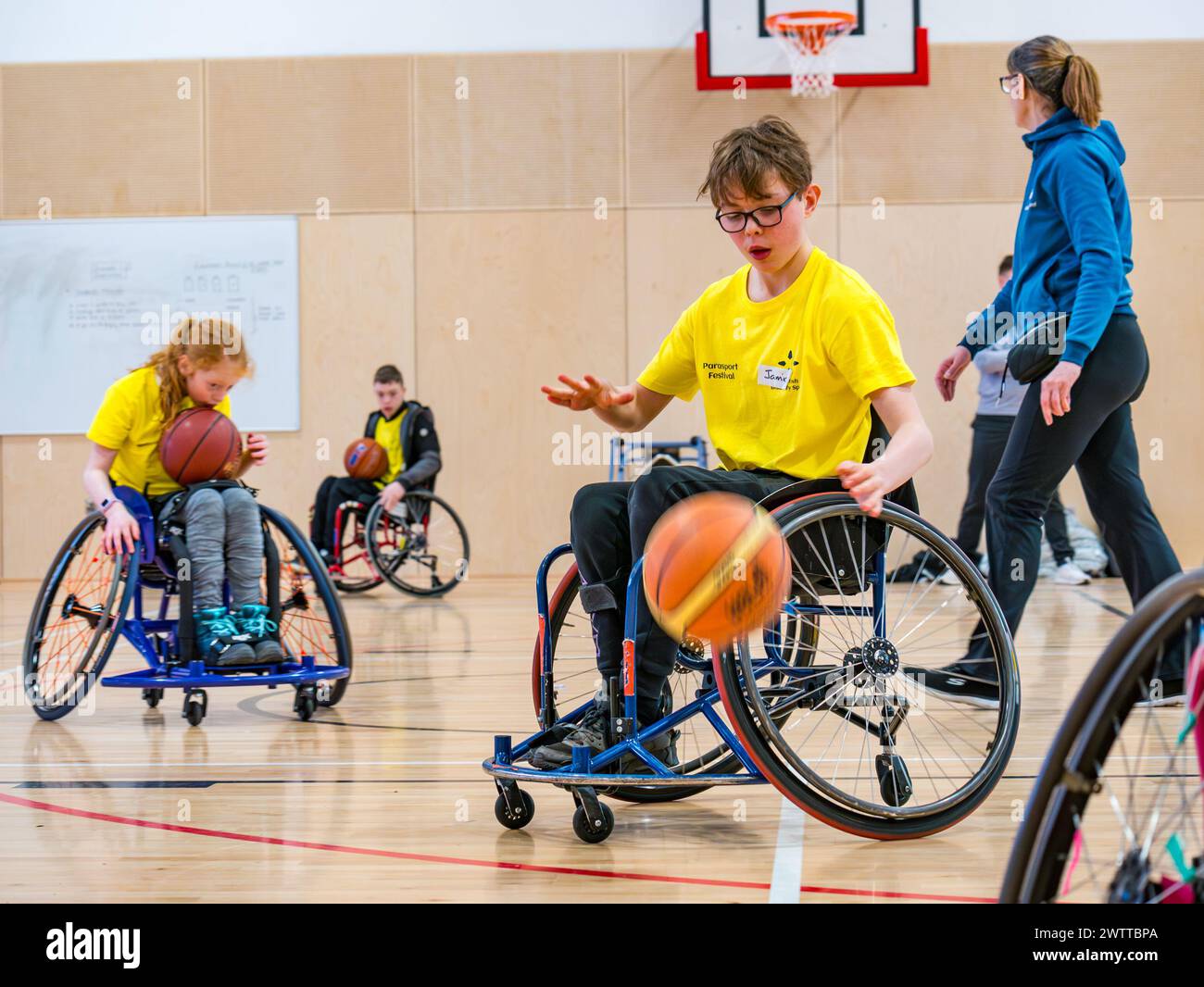 Winchburgh Academy, West Lothian, Scotland, UK, 19th March 2024. Parasport Festival for children with disabilities: Scottish Disability Sport is holding a series of countrywide events to offer young people with physical disabilities, hearing loss and vision impairments an opportunity to try a wide range of sports delivered by local qualified coaches. Pictured: Jamie Carter (13 years with a right hemiplegia). Children try wheelchair basketball even if they do not use a wheelchair. Credit: Sally Anderson/Alamy Live News Stock Photo