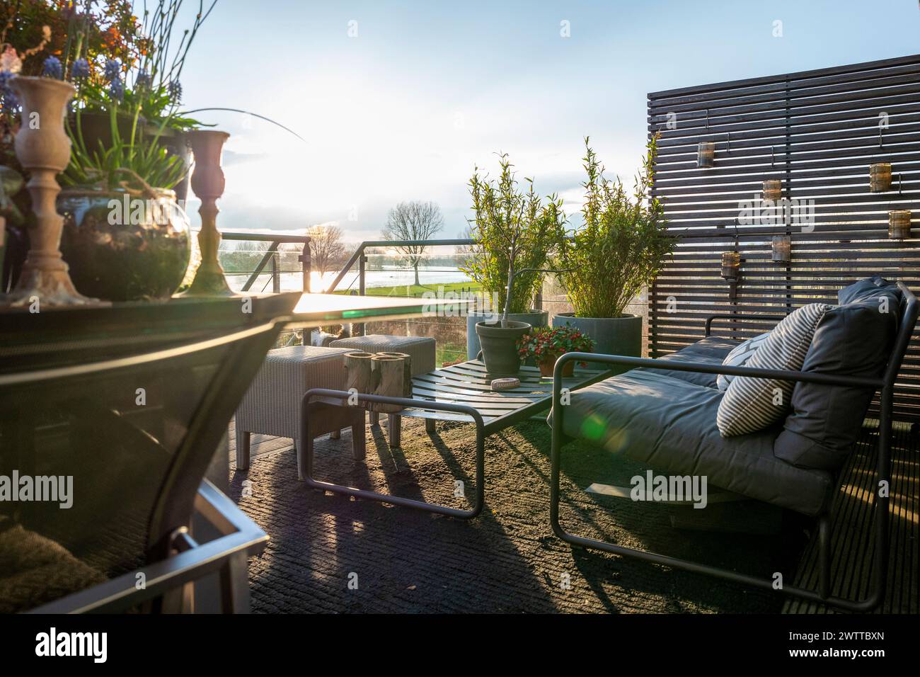 A cozy outdoor patio bathed in warm sunlight. Stock Photo