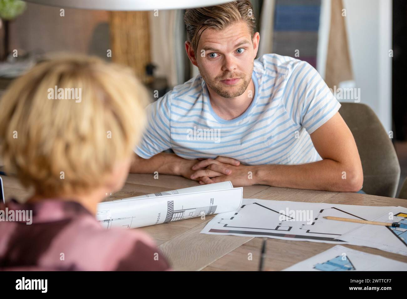 Focused conversation over architectural plans Stock Photo
