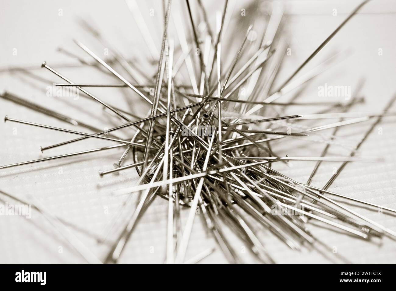 A monochrome close-up of scattered sewing needles Stock Photo