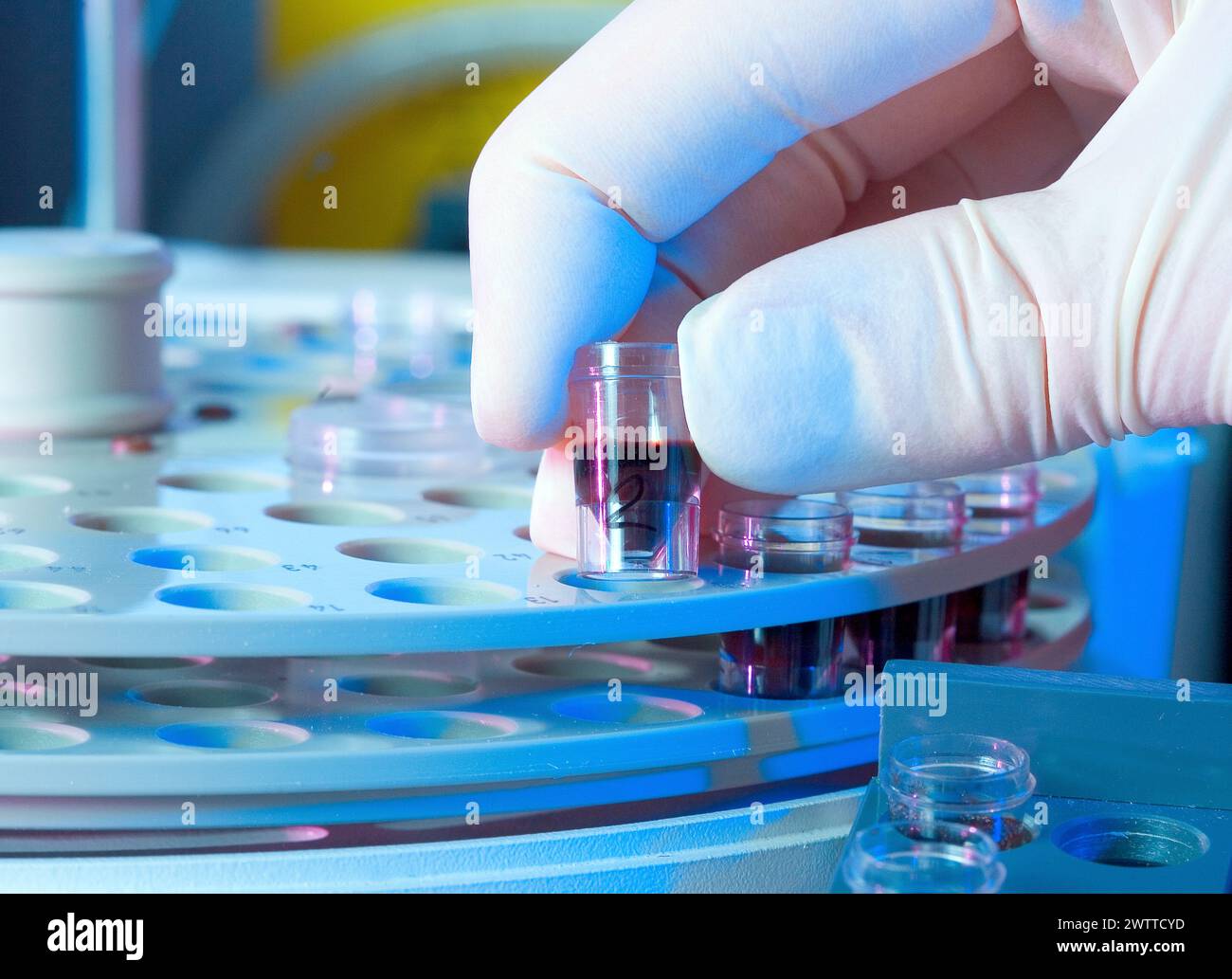 Scientist placing a blood sample into a centrifuge for analysis. Stock Photo