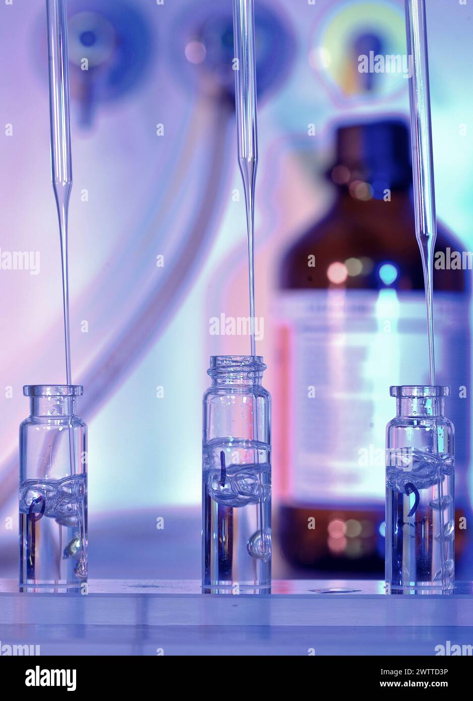 Pipettes dispensing liquid into sample vials in a science laboratory