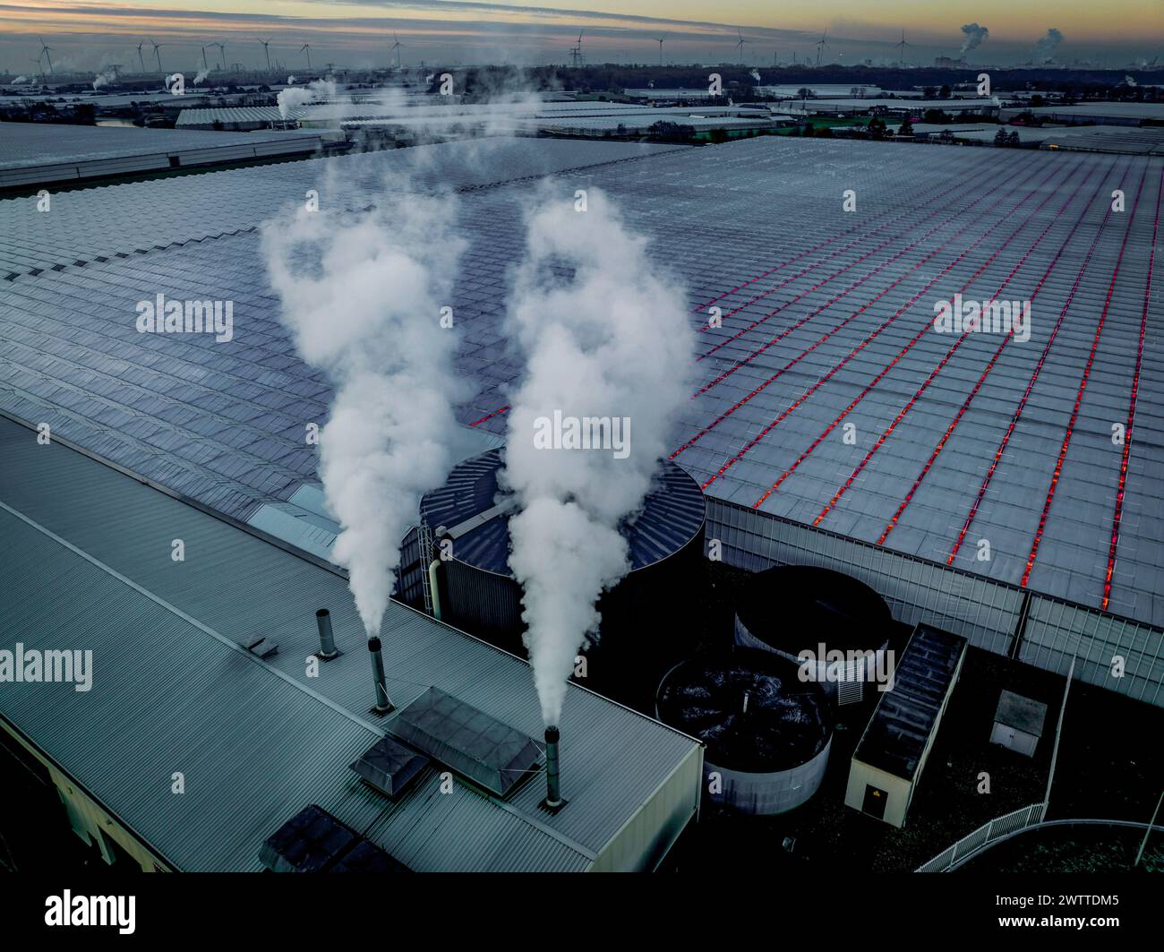Industrial facility emitting smoke at dusk Stock Photo