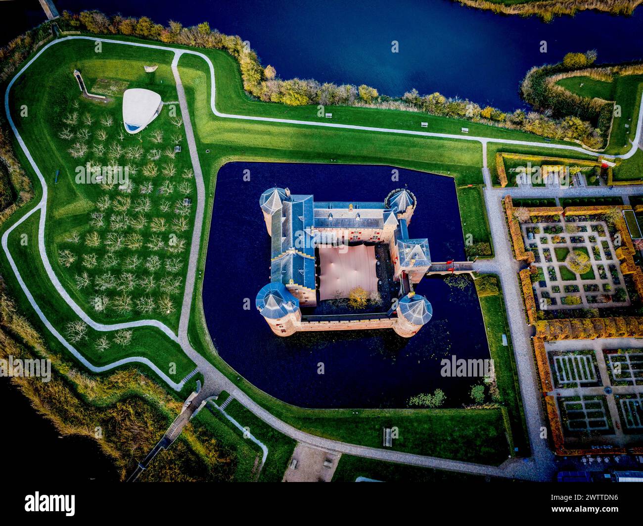 Aerial view of a majestic castle surrounded by lush greenery and water ...