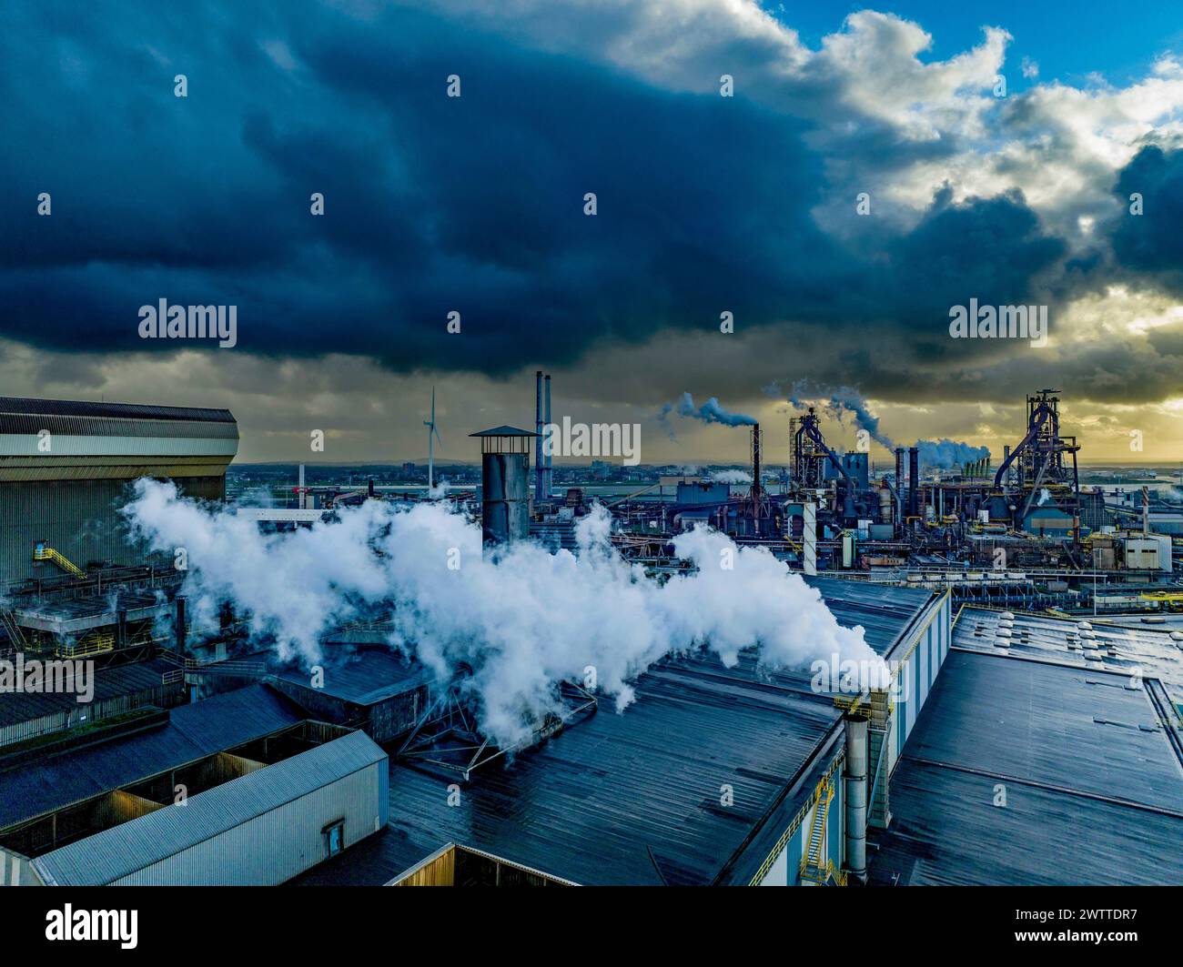 Industrial landscape under a dramatic cloudy sky at dusk. Stock Photo