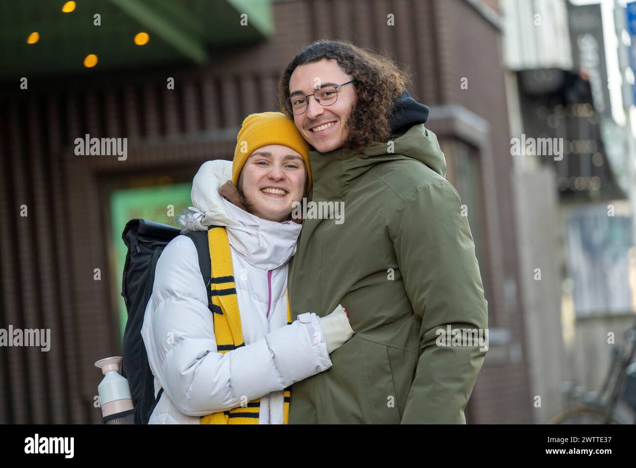 Two friends sharing a joyful embrace on a city street. Stock Photo