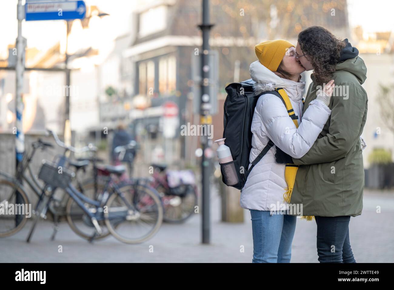 A tender moment as a couple kisses on a city street Stock Photo