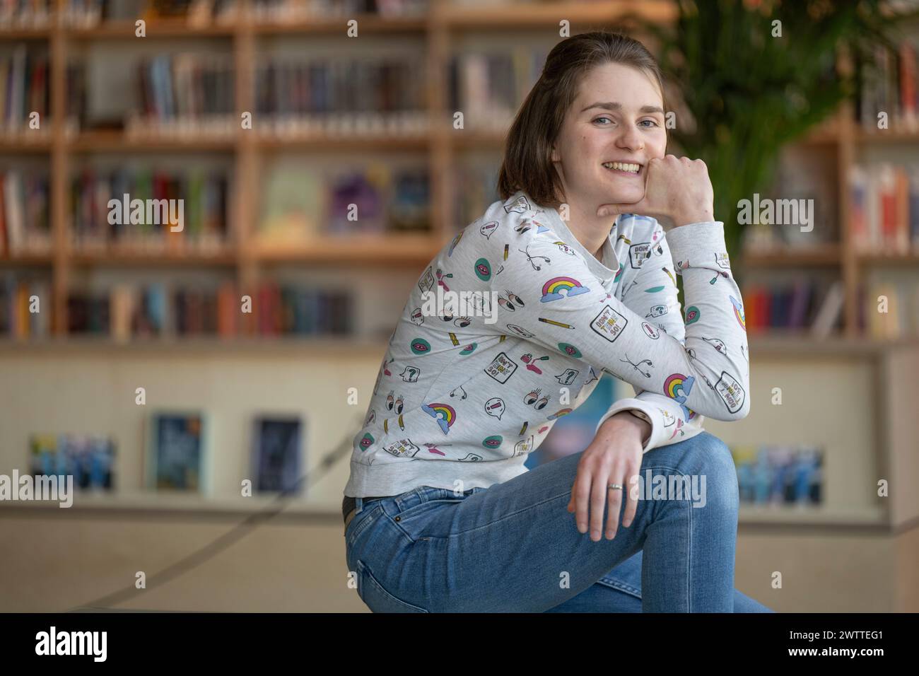 Young woman smiling in a library setting. Stock Photo