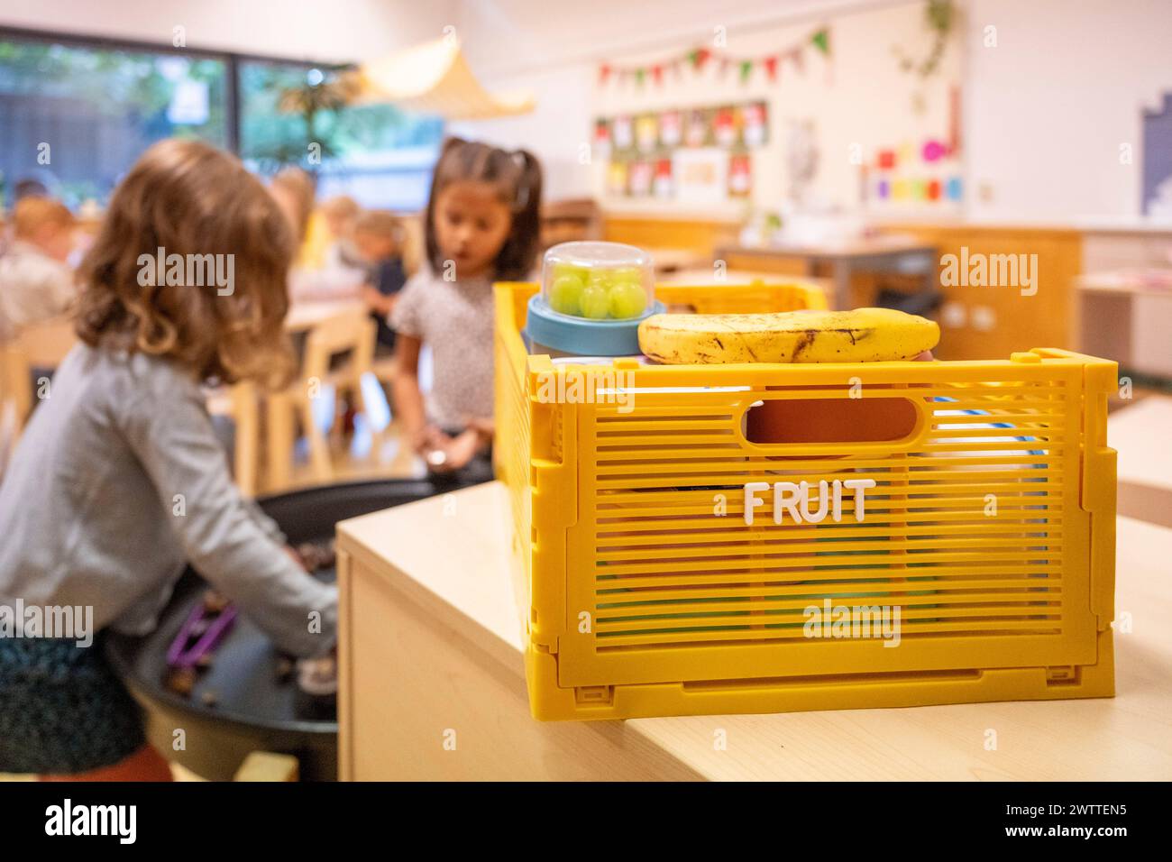Children engaging in playtime activities in a bright classroom setting Stock Photo