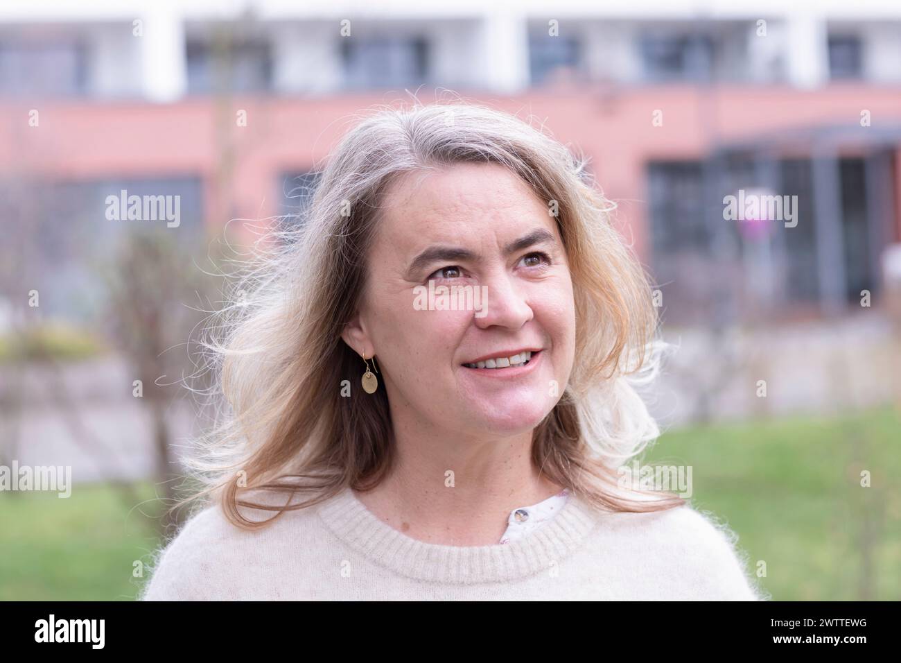 Woman smiling outdoors on a cloudy day Stock Photo
