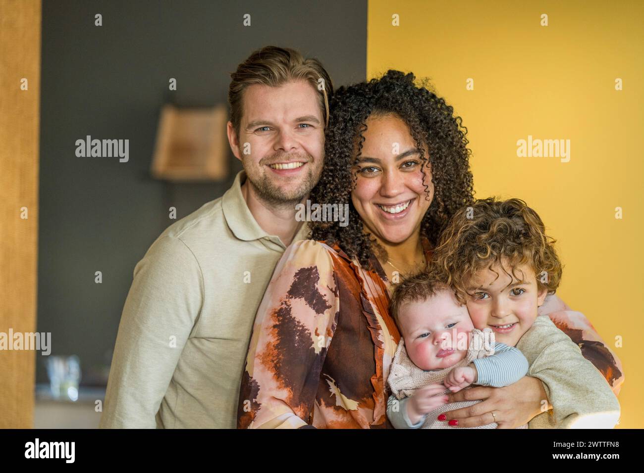 Happy family embracing at home with a cheerful vibe. Stock Photo