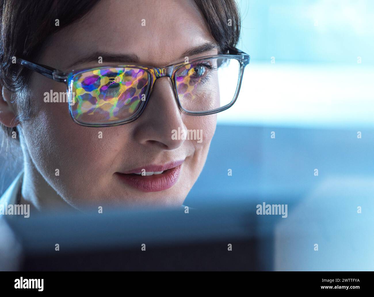 Female STEM scientist using artificial intelligence to design a molecular model of a chemical compound on a computer screen. Stock Photo