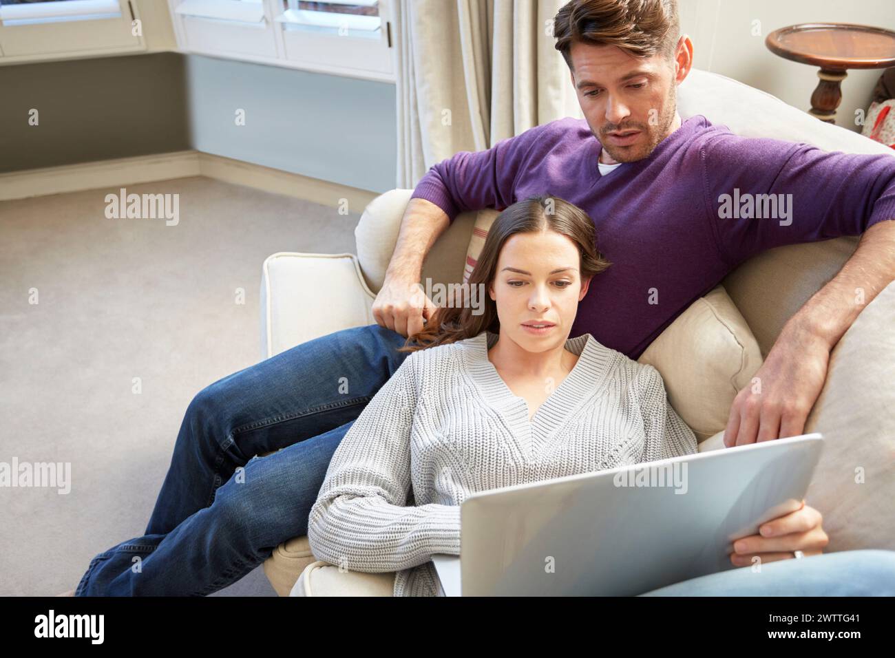 Couple on sofa using a tablet Stock Photo