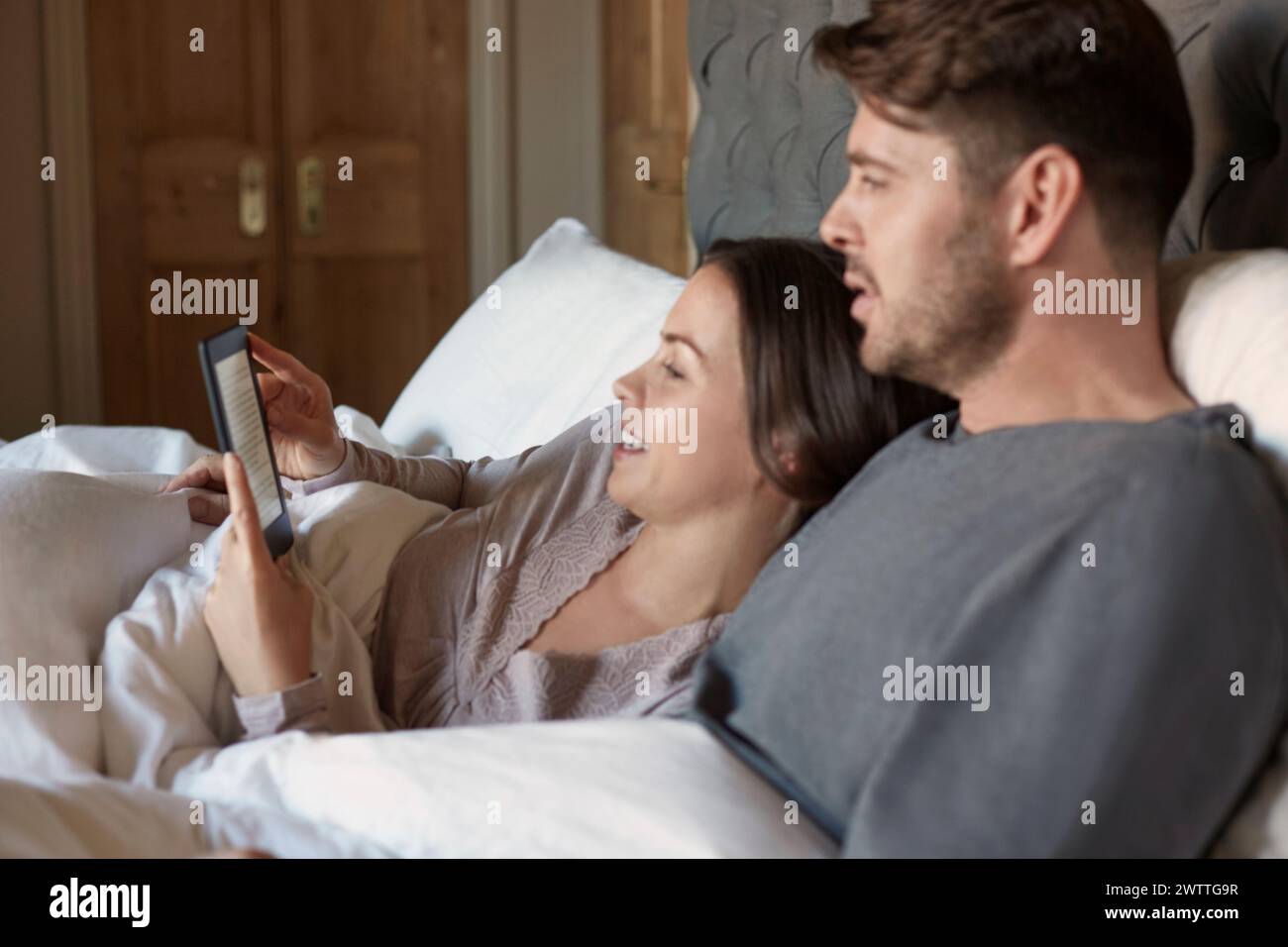 Couple relaxing in bed with a tablet Stock Photo