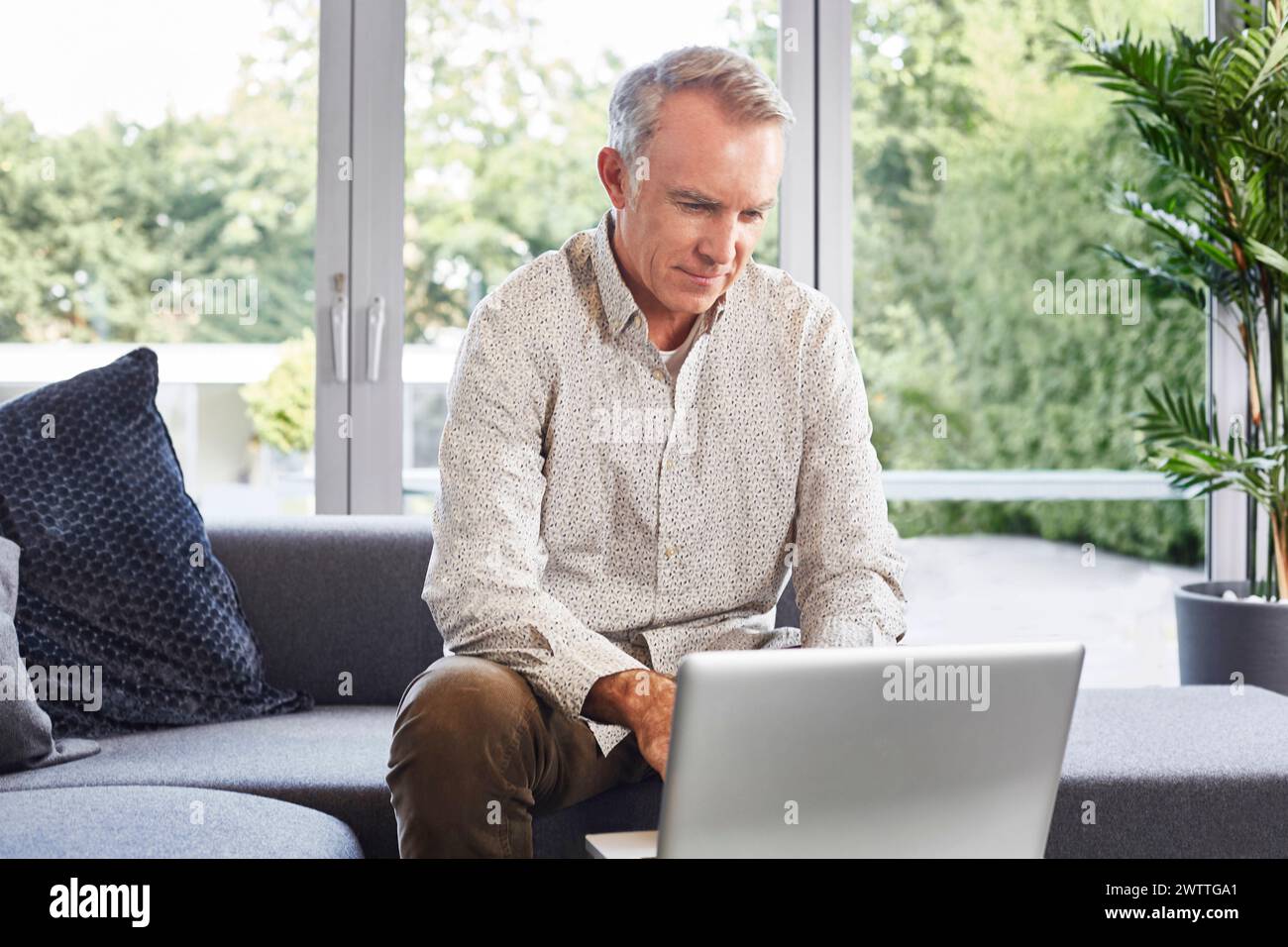 Man working on laptop at home Stock Photo