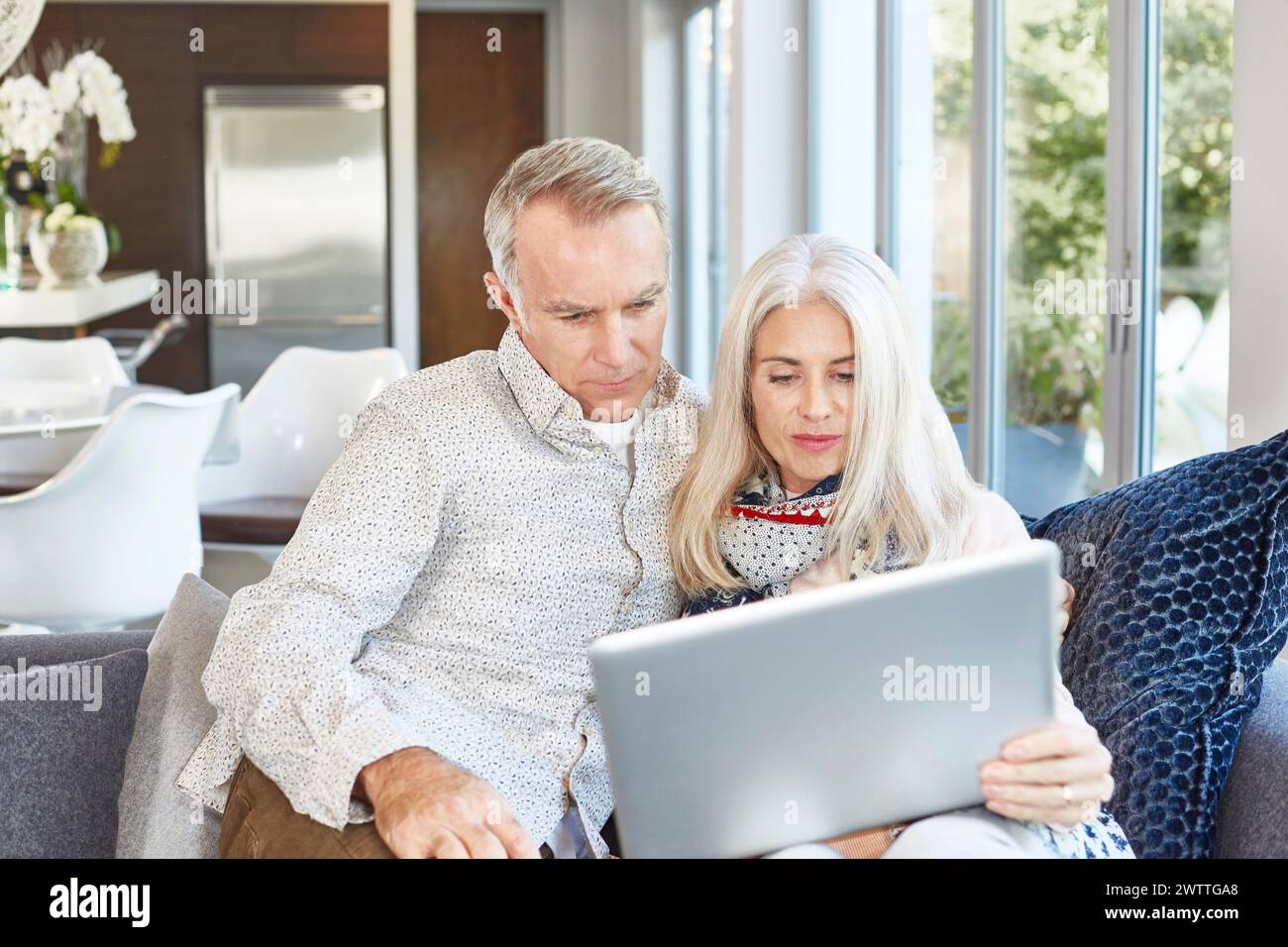 Couple using a laptop together on a sofa Stock Photo