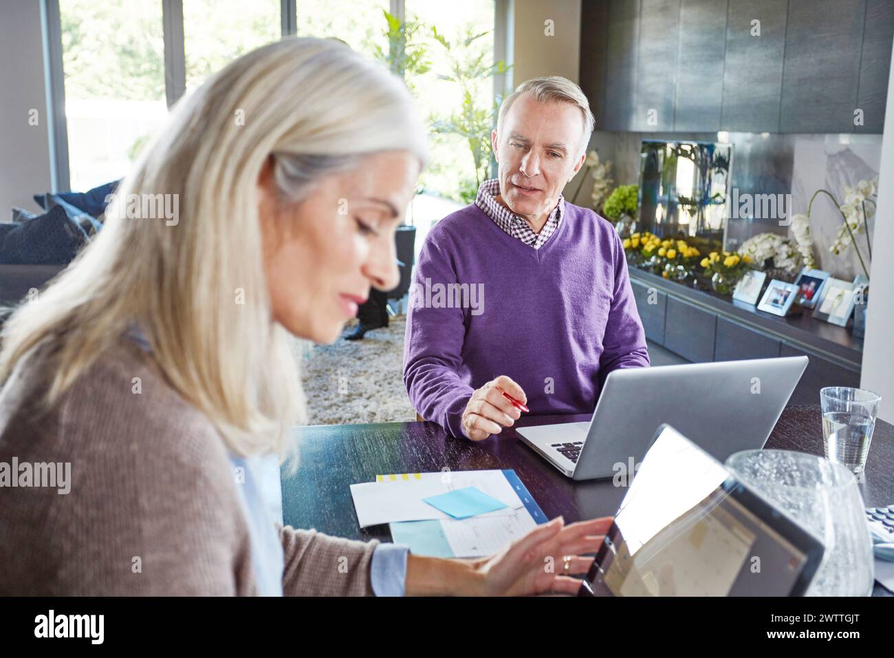 Two adults working at a home office Stock Photo