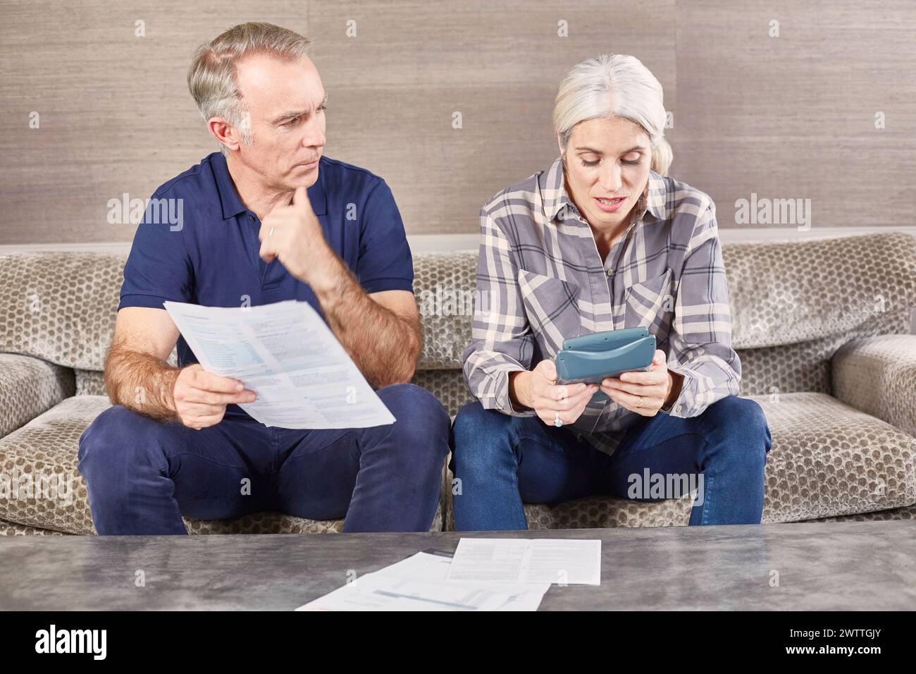 Two adults reviewing documents on a couch Stock Photo