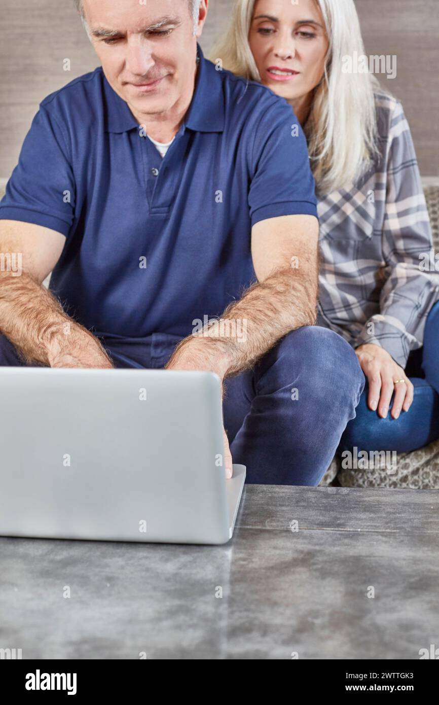 Couple using a laptop on a couch Stock Photo