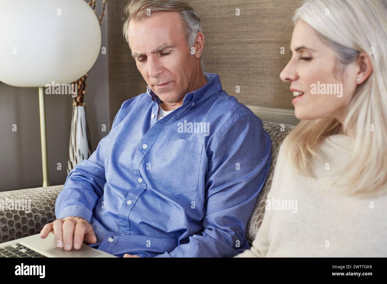Man and woman looking at a laptop screen. Stock Photo
