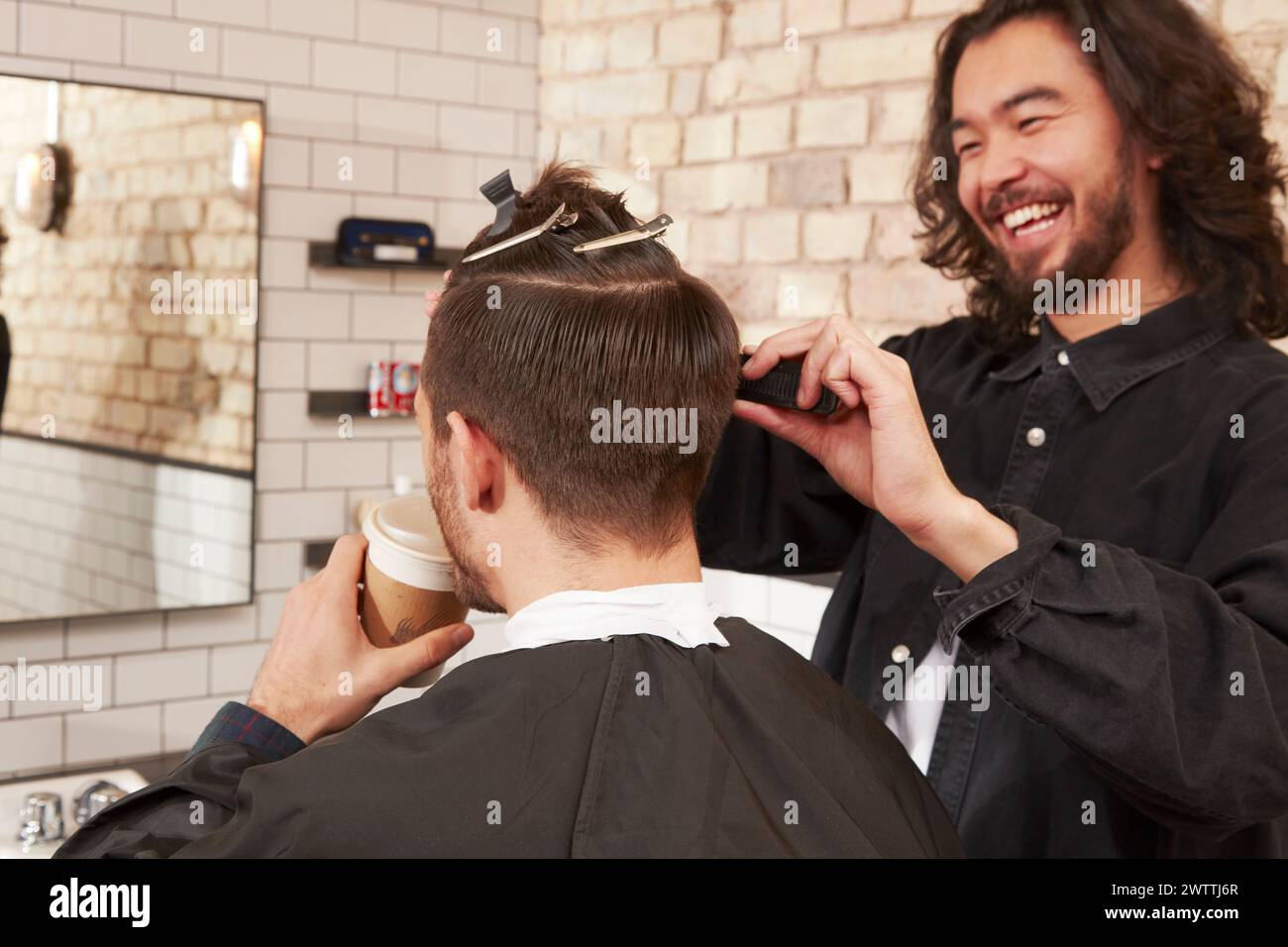 Barber cutting hair in a salon Stock Photo