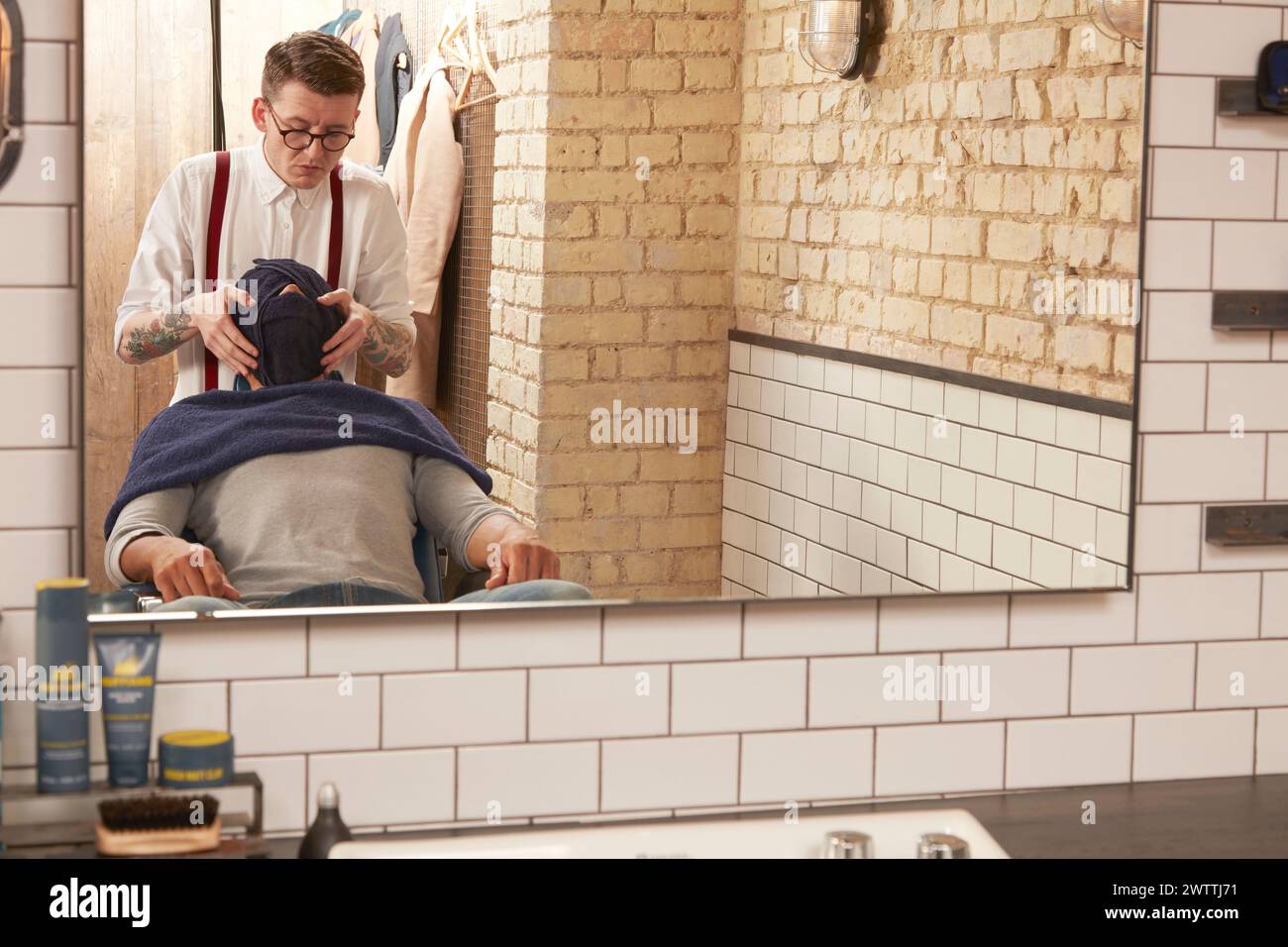Barber giving a haircut to a client Stock Photo