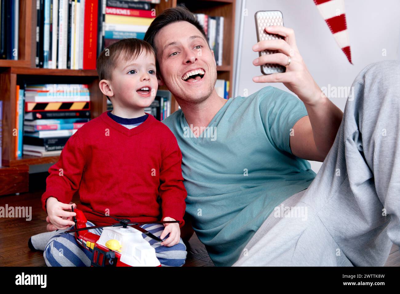 Man and child taking a selfie on the couch Stock Photo