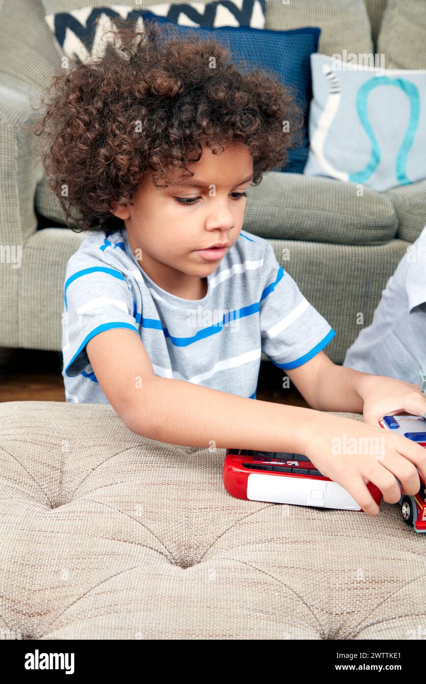 Child playing with toy cars on couch Stock Photo - Alamy