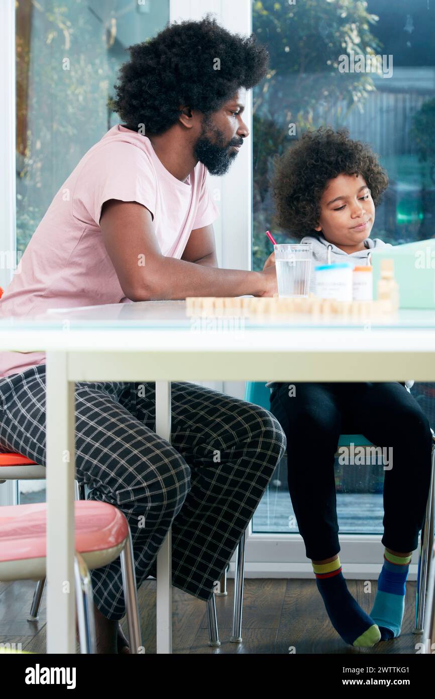 Father and child enjoying time together at a table. Stock Photo