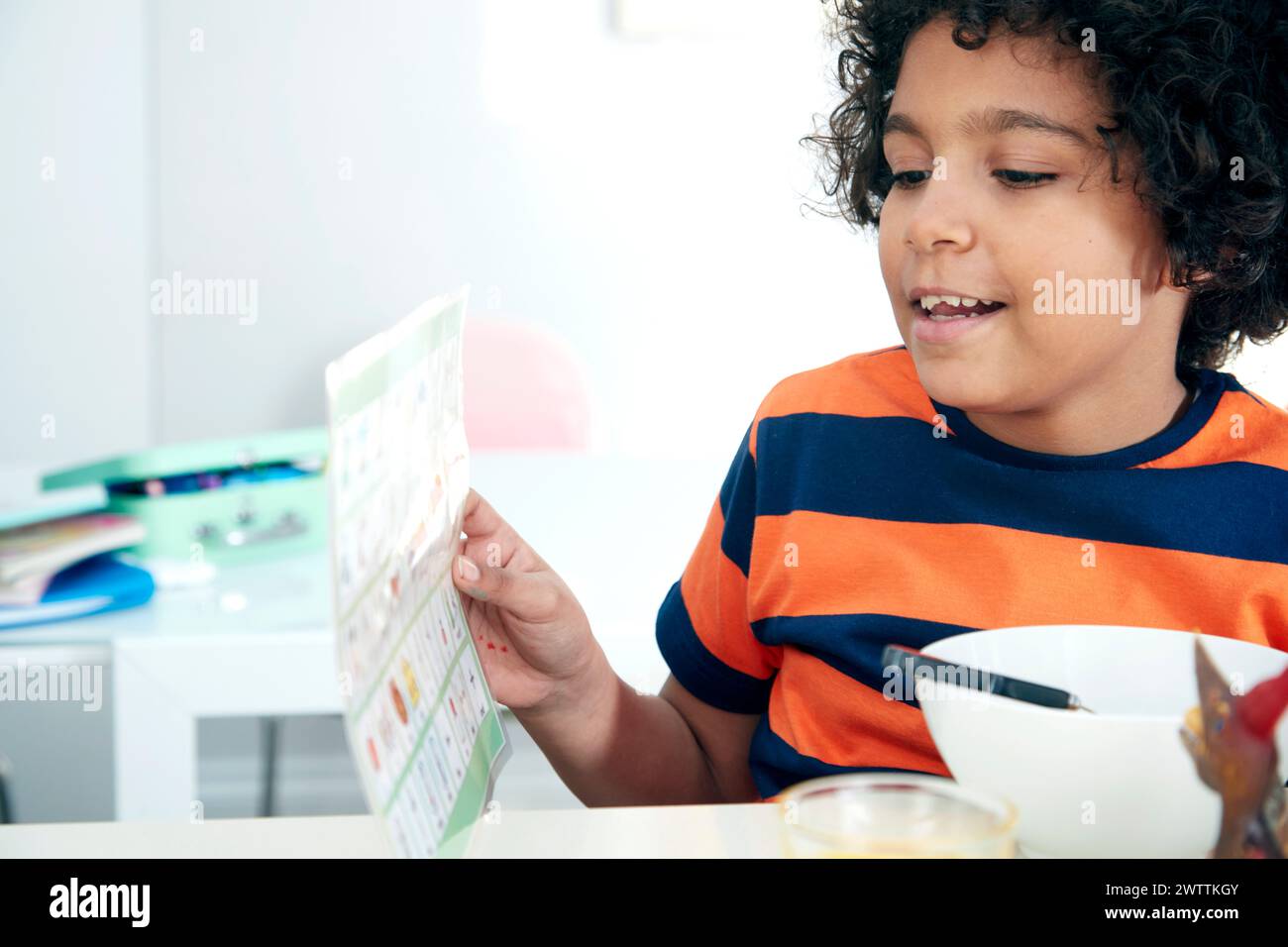Child reading a menu at a table Stock Photo