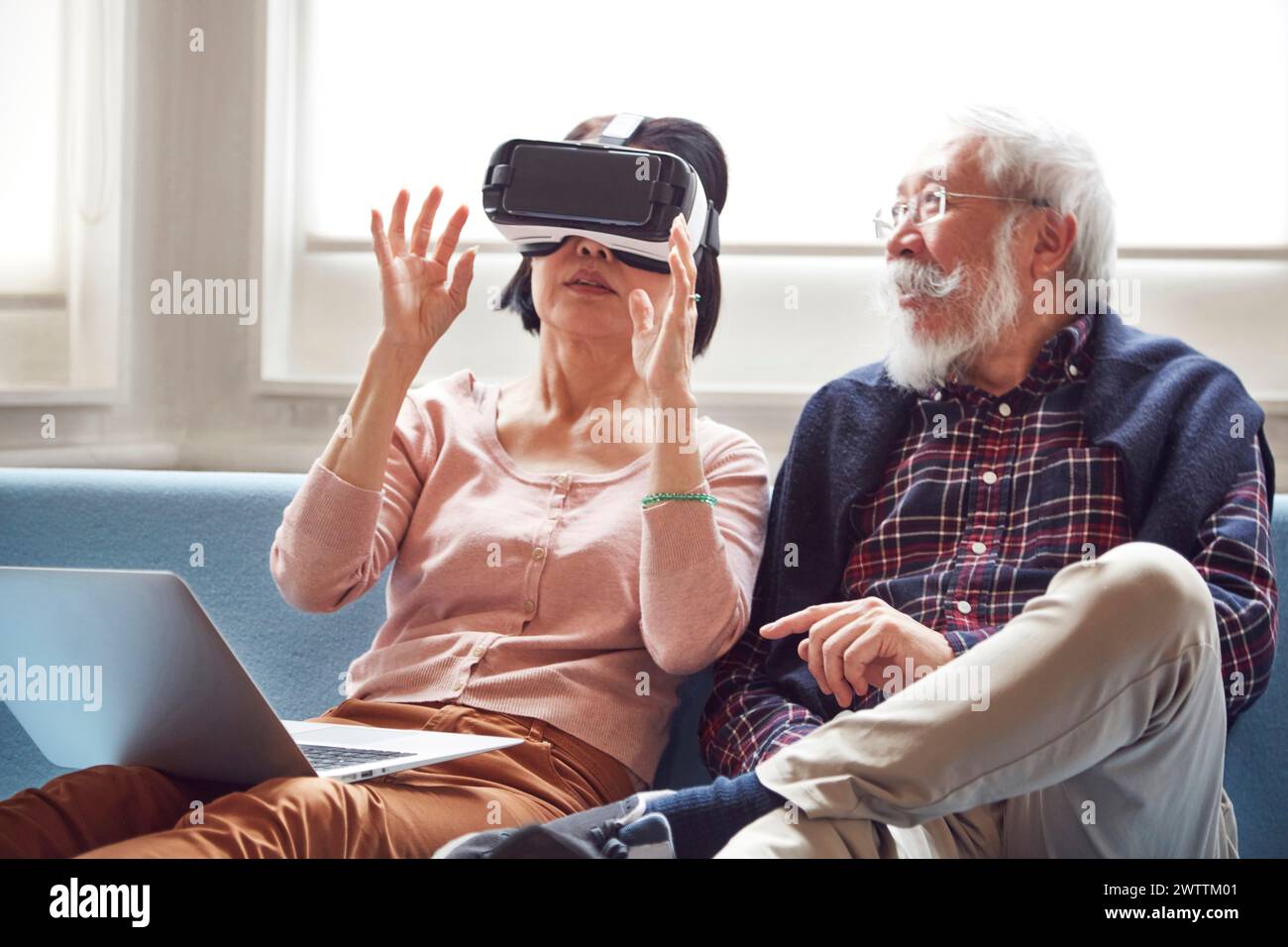 Elderly couple experiencing virtual reality on the couch Stock Photo