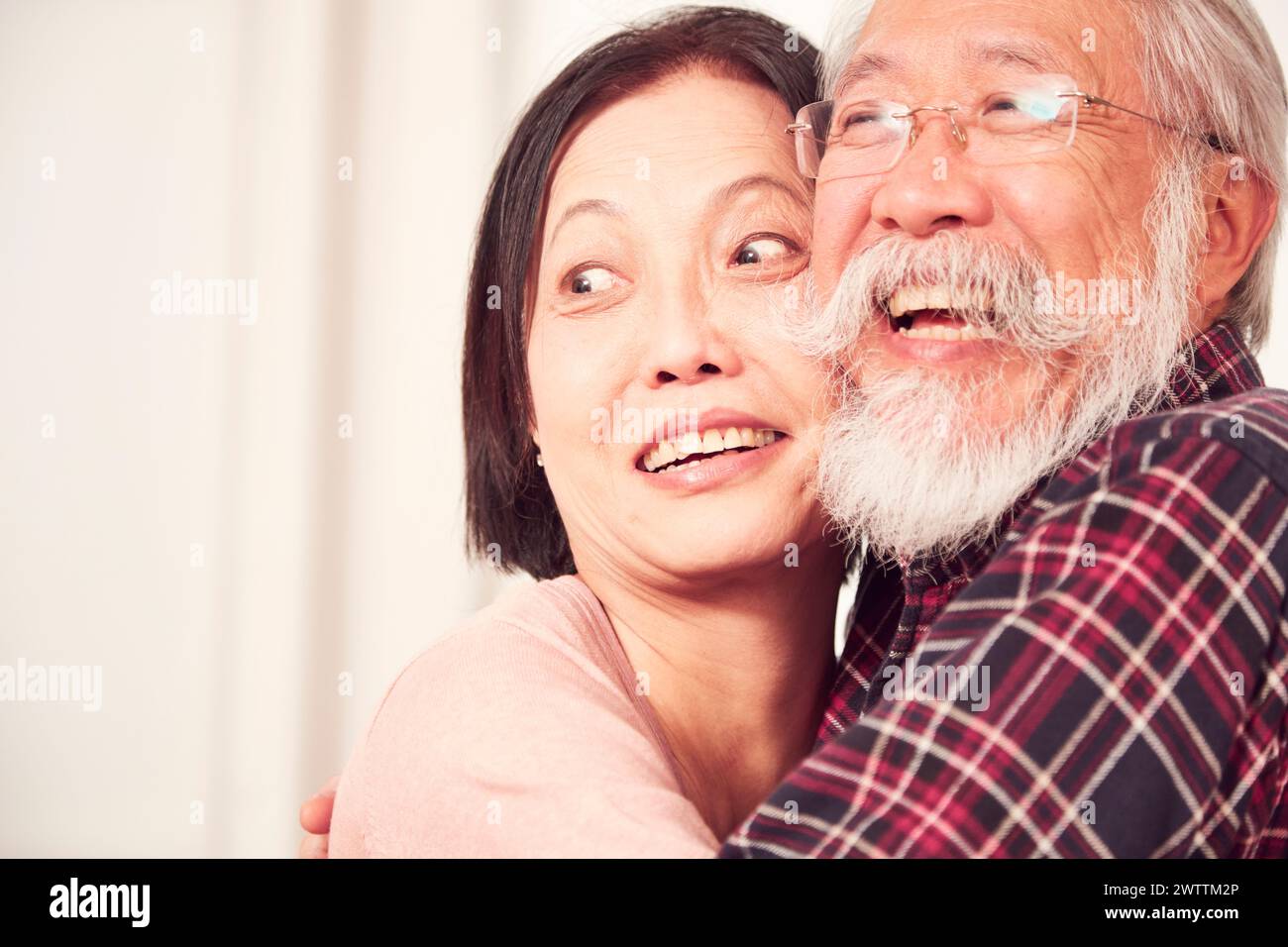 Elderly couple embracing and smiling Stock Photo