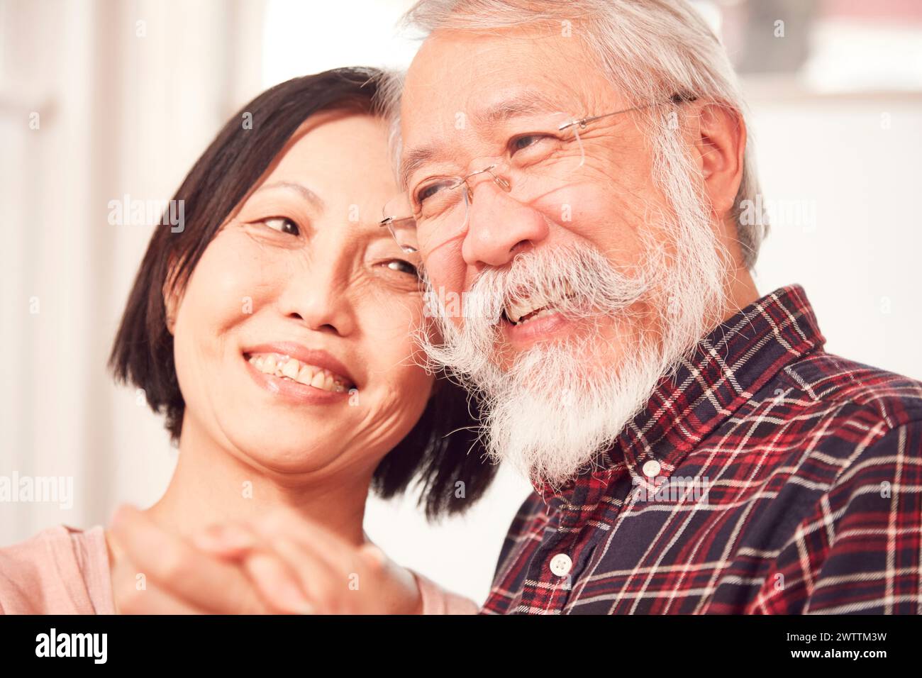 Smiling elderly man and middle-aged woman embracing Stock Photo