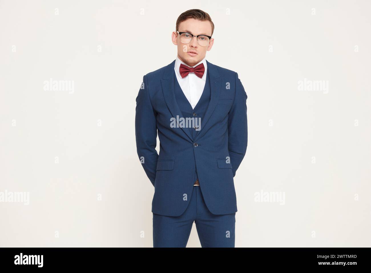Man in blue suit with red bow tie and glasses Stock Photo - Alamy