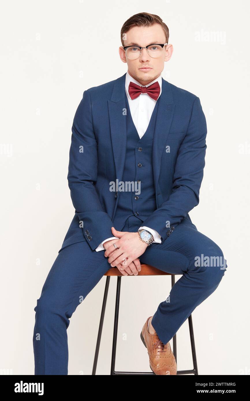 Man in a suit sitting on a stool Stock Photo