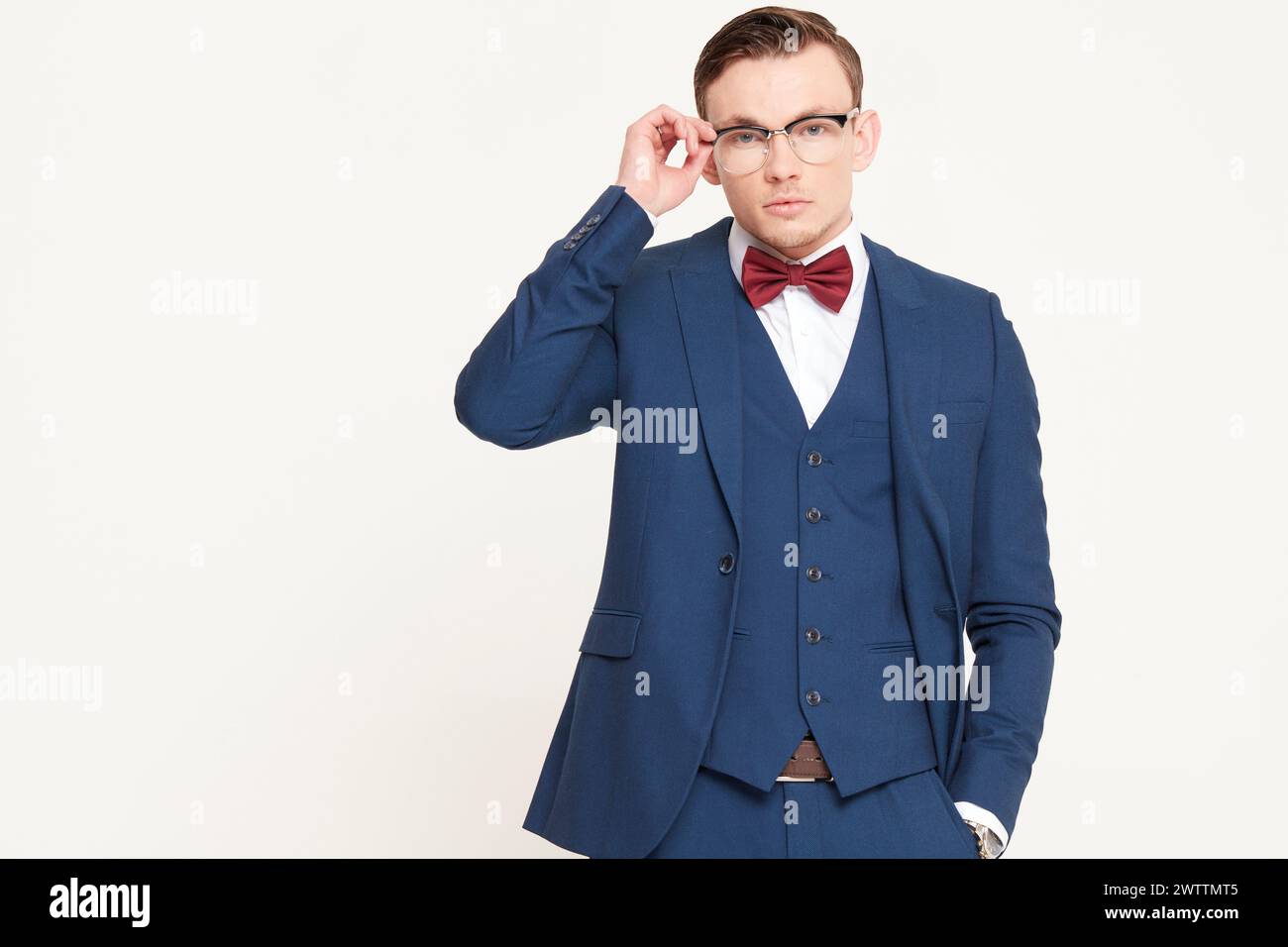 Man in a blue suit adjusting his glasses Stock Photo