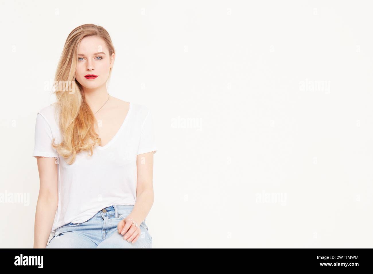 Woman sitting in blue jeans hi-res stock photography and images - Alamy