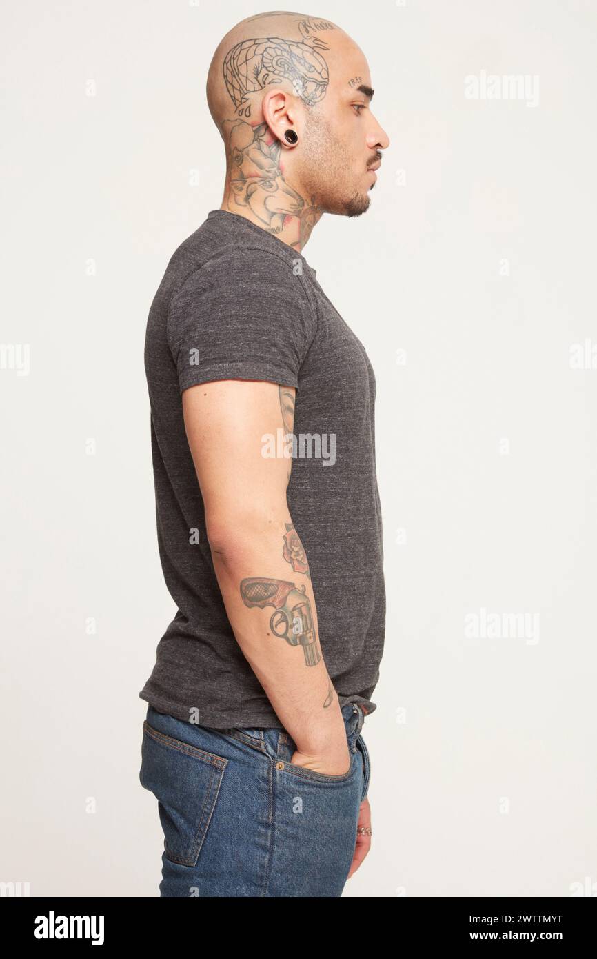 Man with tattoos in profile view Stock Photo