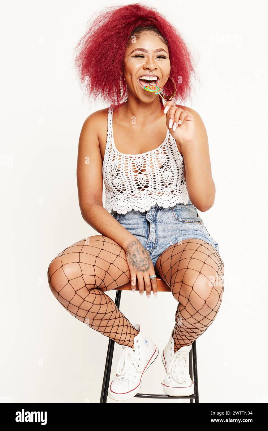 Woman with red hair sitting on stool Stock Photo