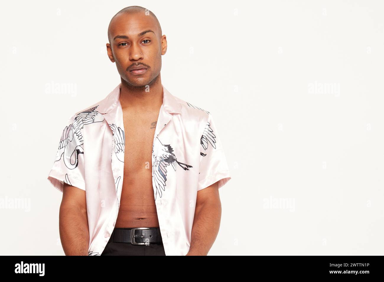 Man in silk shirt posing against white background Stock Photo