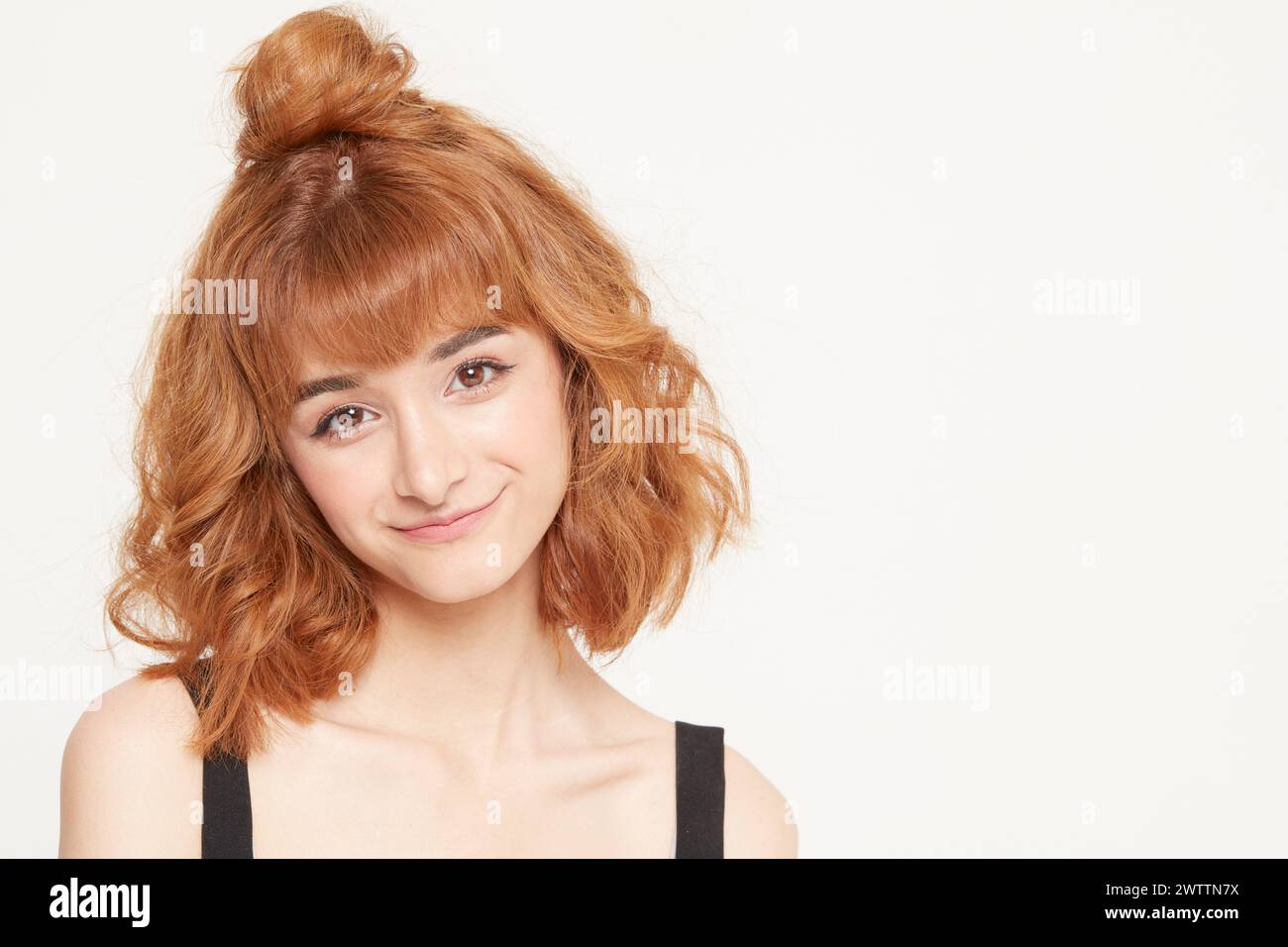 Smiling woman with redhead bun hairstyle Stock Photo