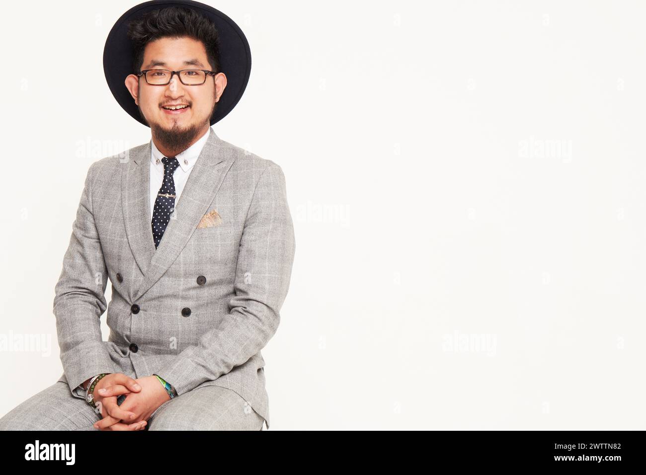 Man in a hat sitting in a suit Stock Photo